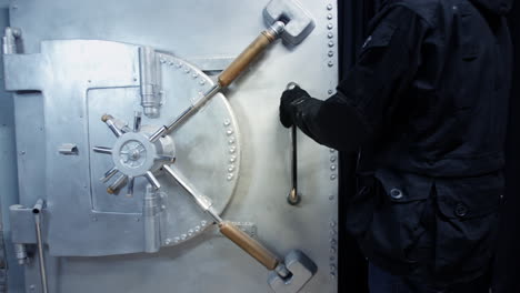 A-bank-robber-breaks-into-a-bank-vault-and-opens-the-safe-door