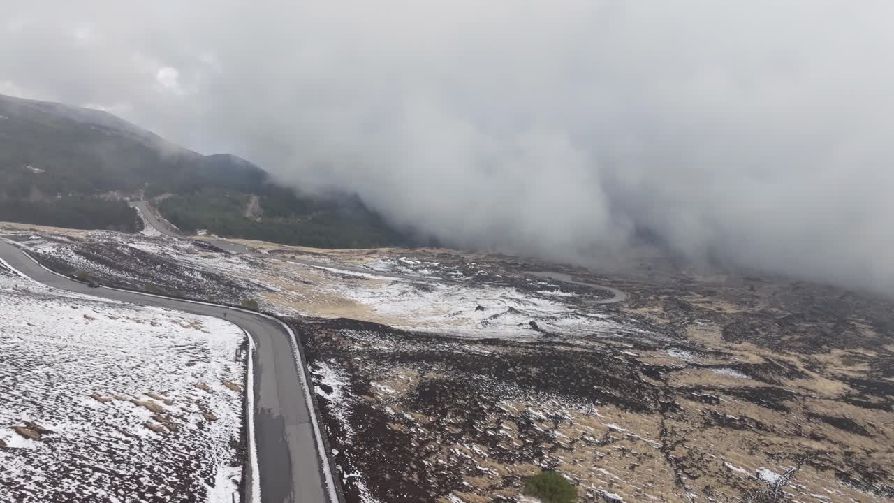 una foto aérea de las regiones montañosas de sicilia, con partes del terreno cubiertas de nieve mientras que otras áreas muestran hierba que emerge de debajo