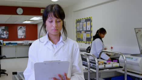 Laboratory-technician-looking-at-clipboard-4k