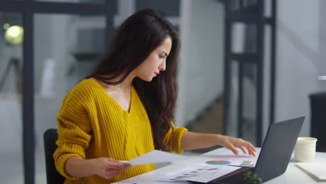 mujer de negocios enfocada leyendo documentos. chica seria comprobando datos