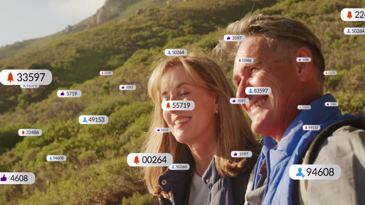 animación de texto e iconos de las redes sociales sobre una pareja caucásica en las montañas