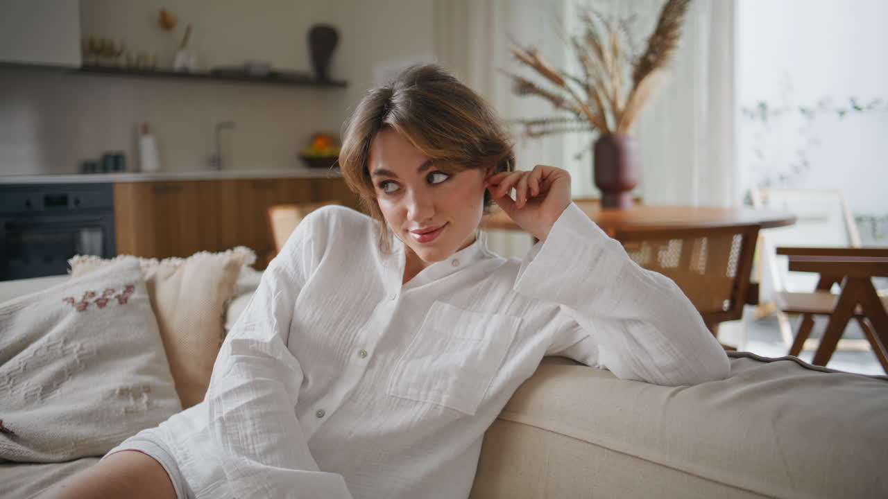 Domestic woman relaxing sofa with thoughtful expression closeup. lady