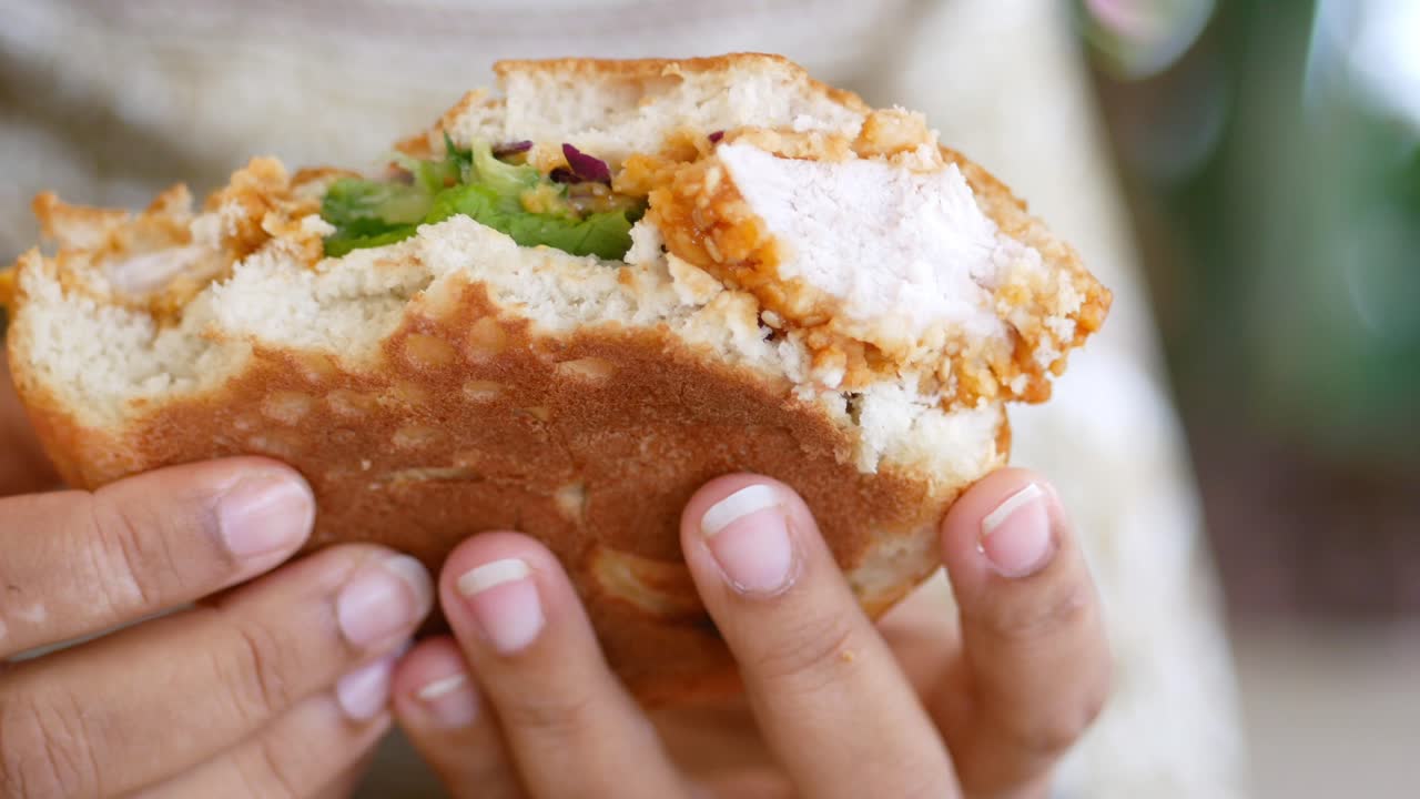 mano con un delicioso sándwich de pollo frito
