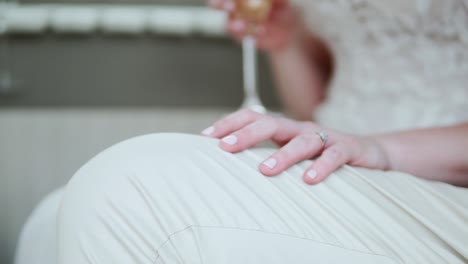 bride's hand on groom's lap on wedding day - selective focus