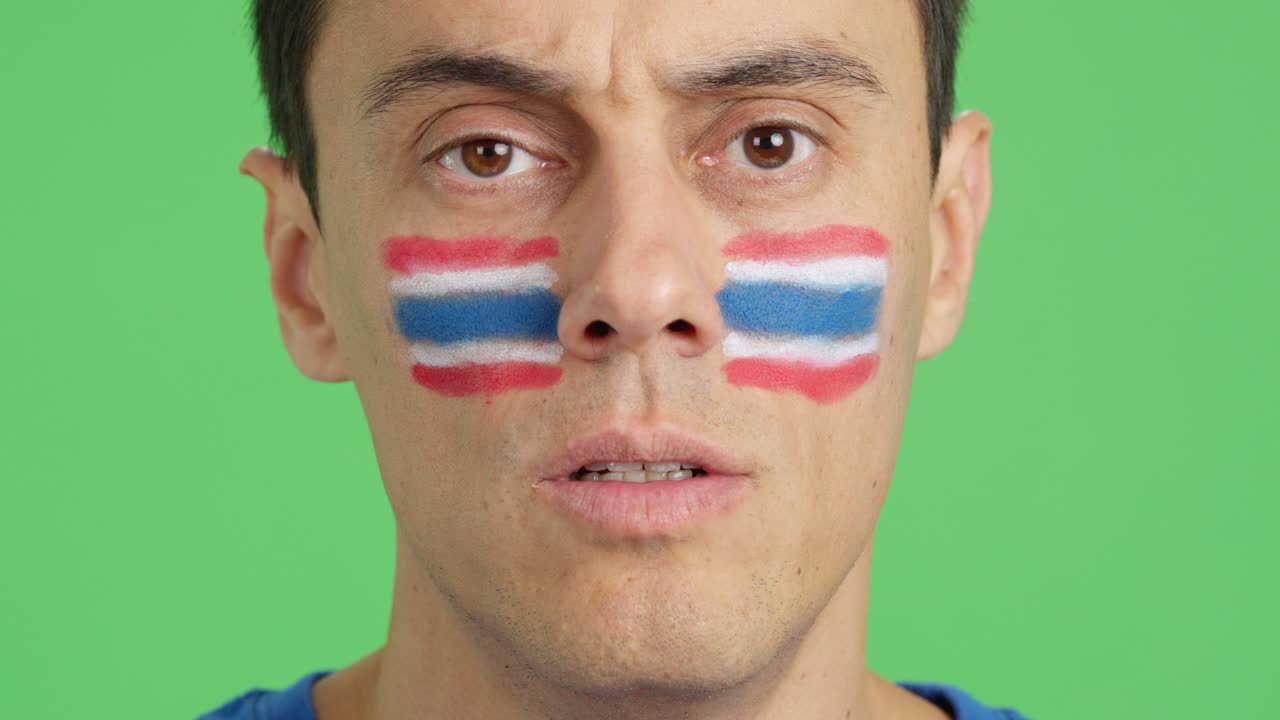 Man with a thai flag painted on the face smiling