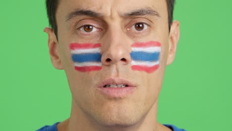 man with a thai flag painted on the face smiling