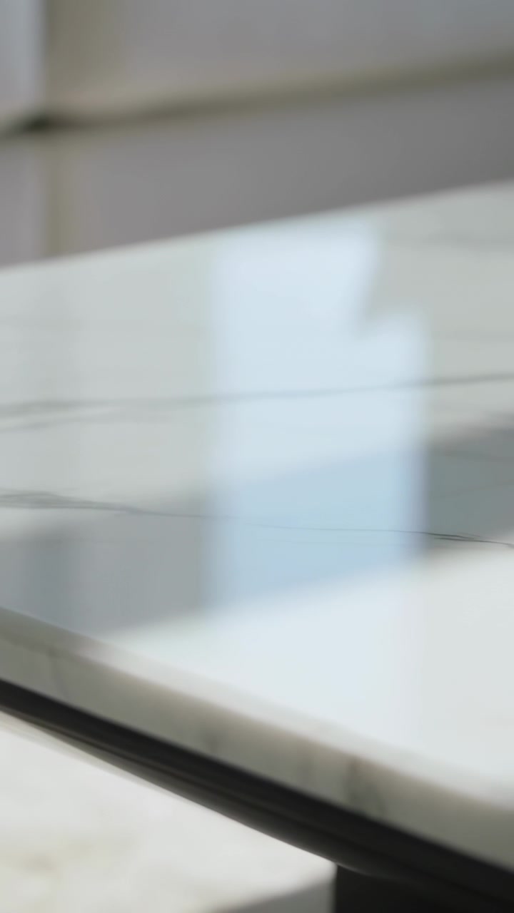 Vertical video: Panning camera revealing slab in kitchen, showcasing grey veining, edge, reflection