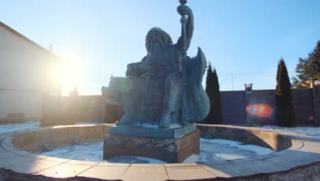 bronze statue of a god in a winter garden