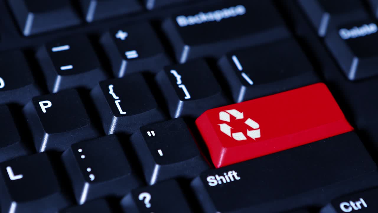 Human finger pushing a red recycle button on the computer keyboard