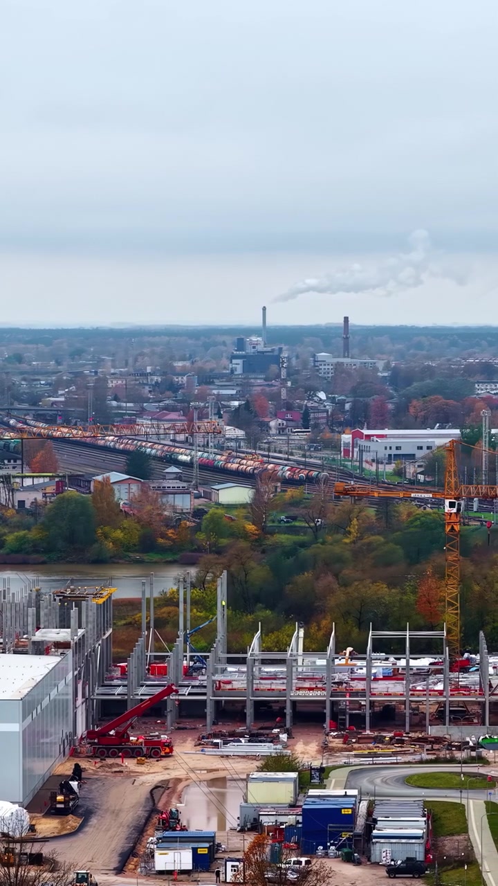 Vista aerea di un cantiere edile con gru in un'area industriale durante il giorno.
