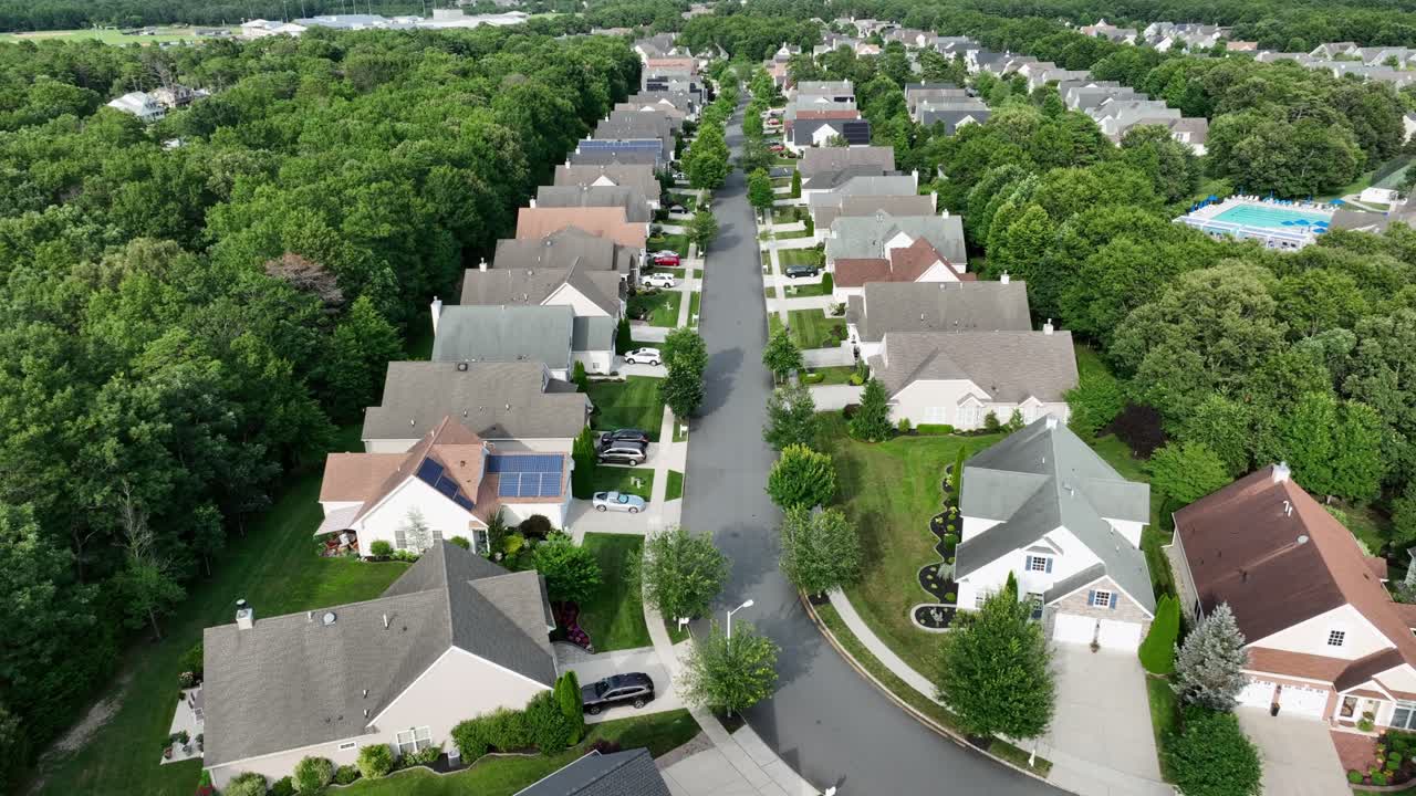 Luxury craftsman and colonial single family houses in Suburbia of City. Aerial approaching shot. Homes with garages in quiet neighborhood. Sunny day in summer with green trees