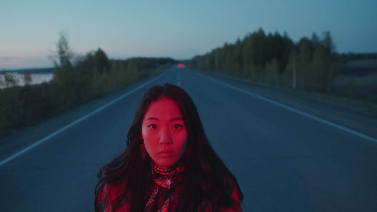 황혼에  빈 길에서 은 빛에 의해 조명 된 아시아 여성의 초상화