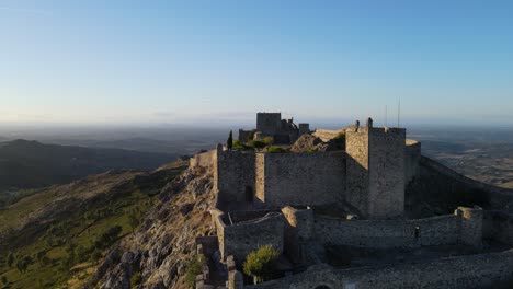 a drone flies over the walls of marvão castle showing people walking within