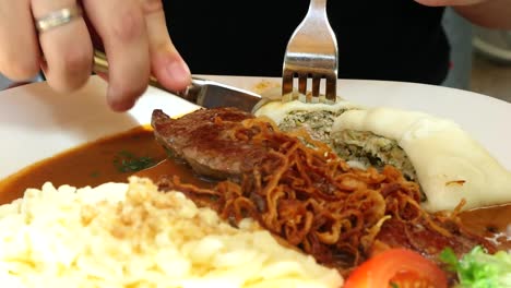 un hombre come maultaschen con spaetzle en un restaurante
