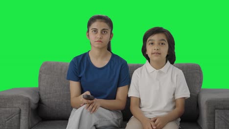 hermanos indios viendo la televisión en casa pantalla verde