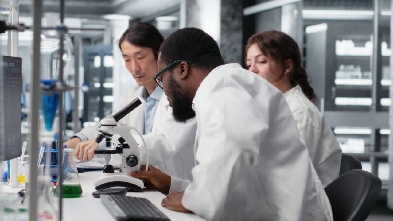 Vertical video Senior researcher records observations from coworkers using microscope