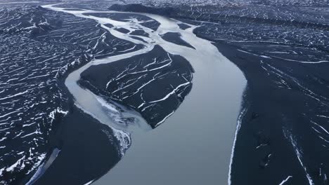 sobrevuelo aéreo del río sula rodeado de un paisaje de basalto volcánico negro en islandia