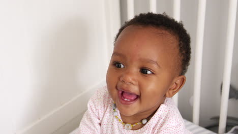 happy baby girl playing in nursery cot shot in slow motion