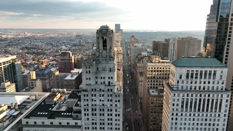 Descending-aerial-of-urban-city-skyscrapers-during-golden-hour-light