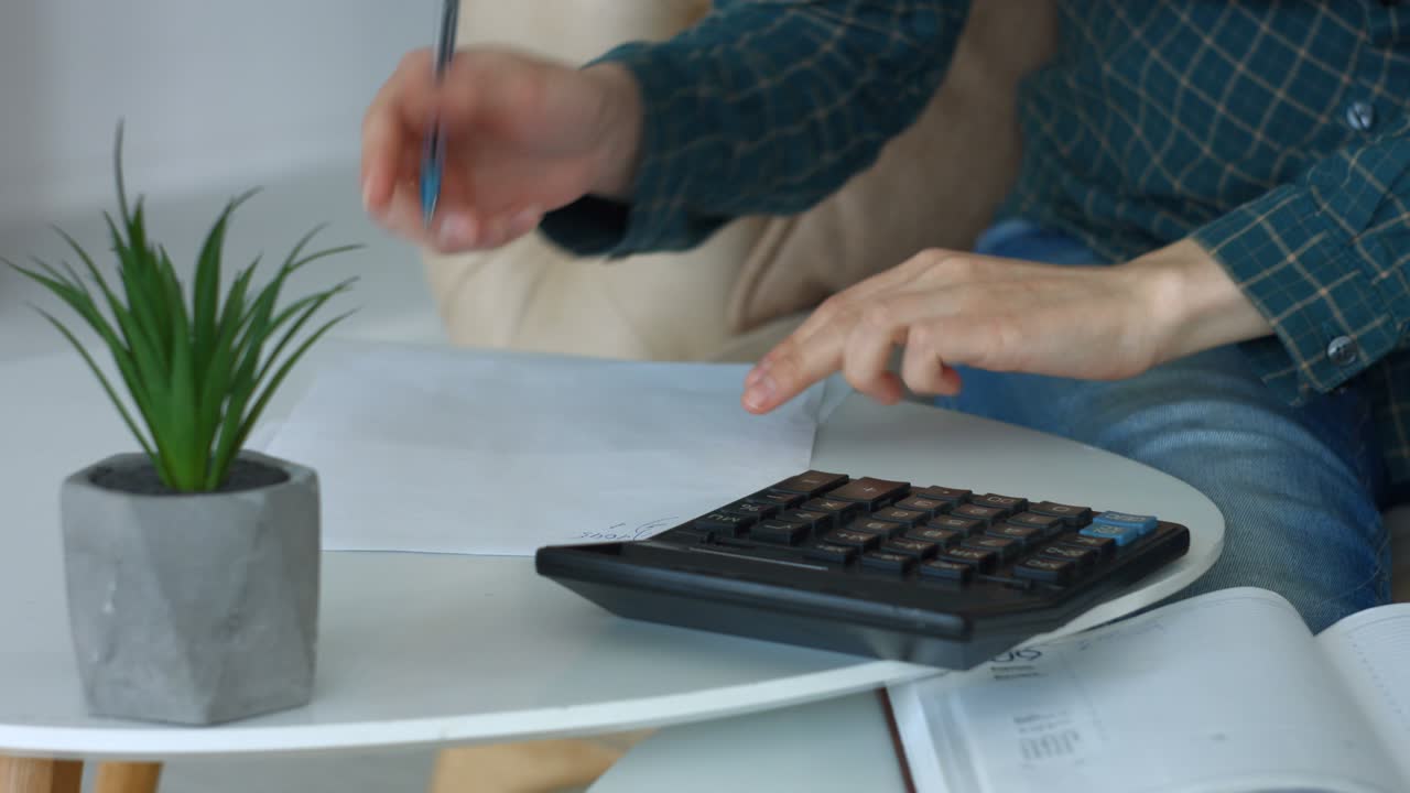 manos femeninas haciendo cálculos en la calculadora