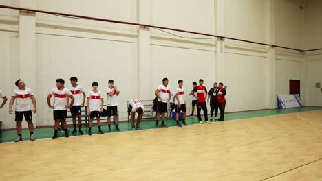 footage of two men's handball teams standing in line in front of their benches before the match. team captains and referees are seen conducting the coin toss to decide the starting team.