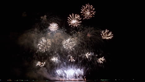 bucle sin fisuras de fondo de fuegos artificiales reales con luces bokeh en el cielo nocturno