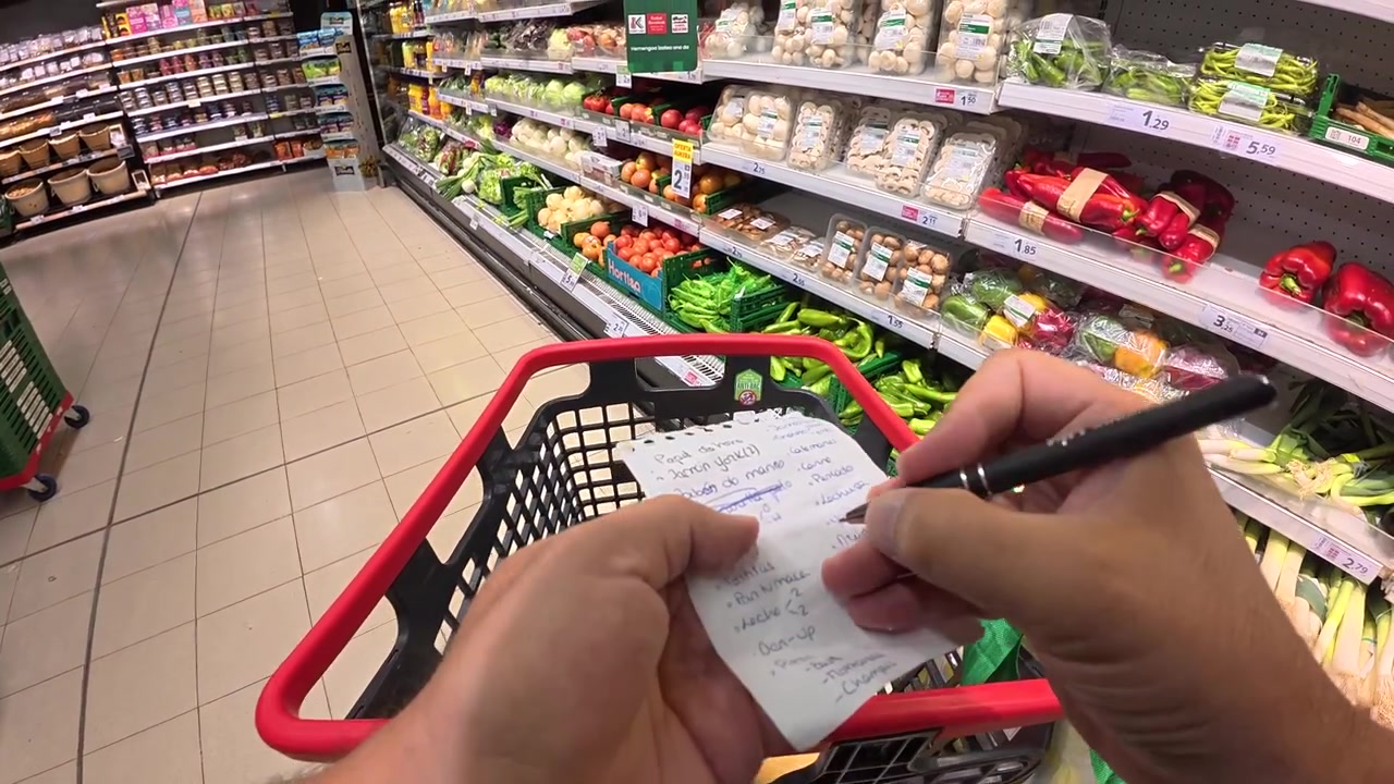 Persona haciendo la compra en un supermercado con una lista.
