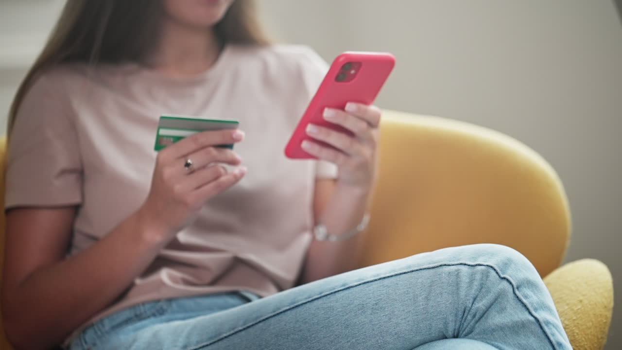 Donna che effettua un pagamento online usando carta di credito e smartphone
