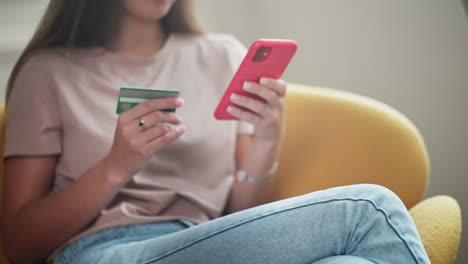 mujer haciendo pagos en línea usando tarjeta de crédito y teléfono inteligente