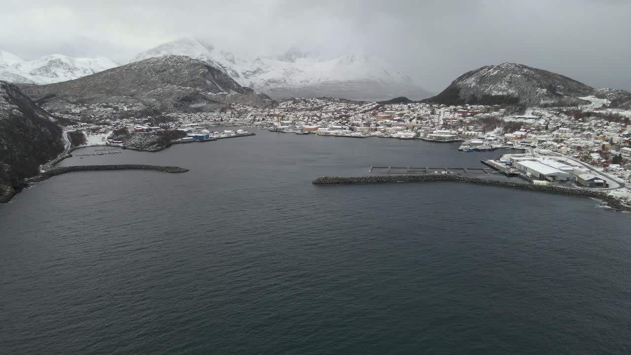 enfoque aéreo - puerto en el pueblo de skjervoy, enclavado bajo montañas nevadas, noruega