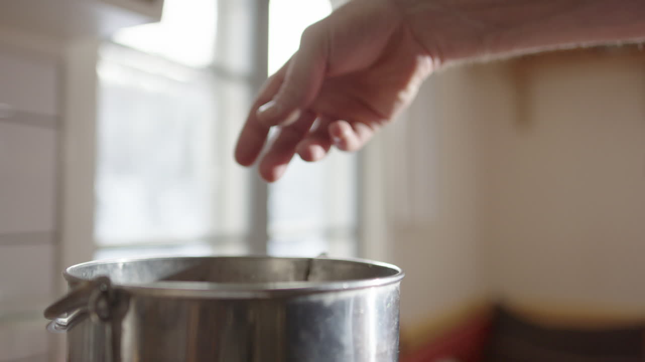Organic spoiled vegetables tossed into stainless steel composting bin, closeup