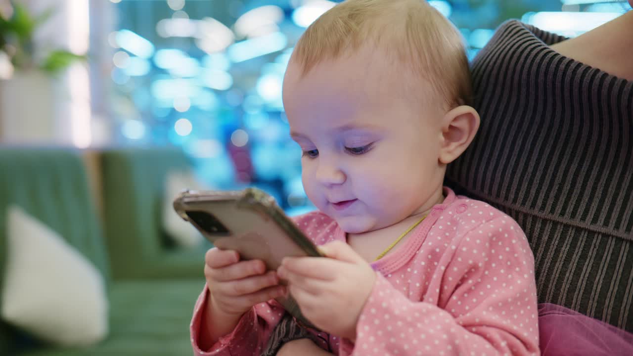 スマートフォンで遊ぶ好奇心旺盛な赤ちゃんの女の子。