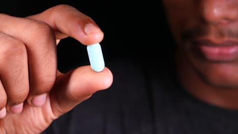 person holding a light blue pill