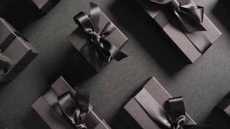 overhead view of black gift boxes tied with black ribbons on black background