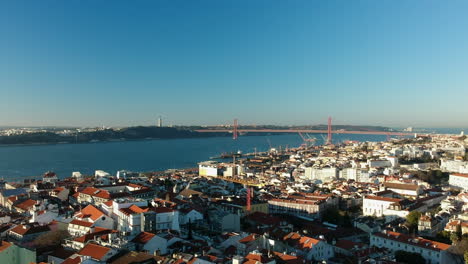 aerial dolly forward above the city of lisbon with ponte 25 de abril and cristo rei in the backgrund, lisbon, portugal