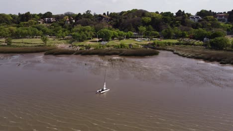 Luftkreisen-Um-Mann,-Der-Katamaran-Aus-Dem-Wasser-Zieht,-Vicente-Lopez-Küste-In-Buenos-Aires