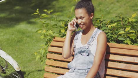 Fröhliche-Frau,-Die-Smartphone-Im-Park-Spricht