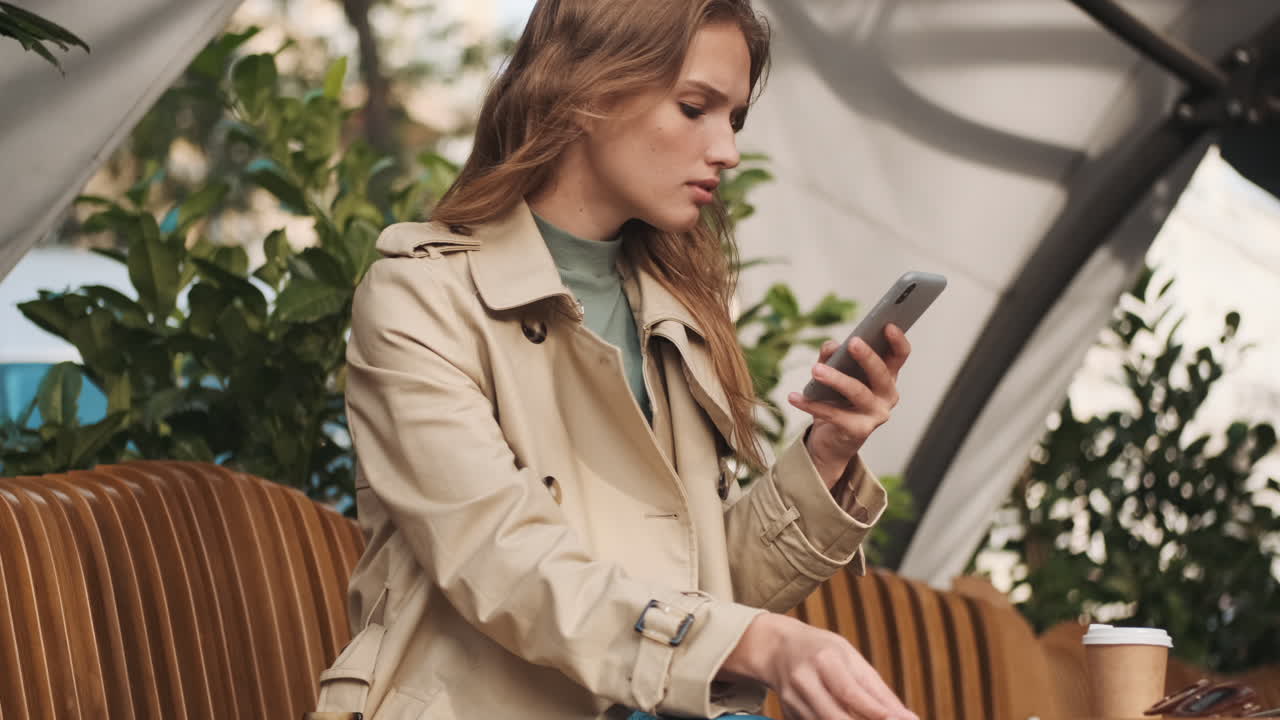 Caucasian female student online shopping on smartphone outdoors.