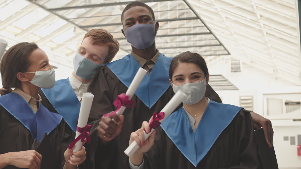 Group of Four Young People with Diplomas