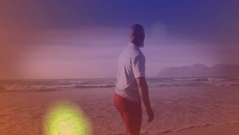 under colorful sky animation, man walking along beach, enjoying view