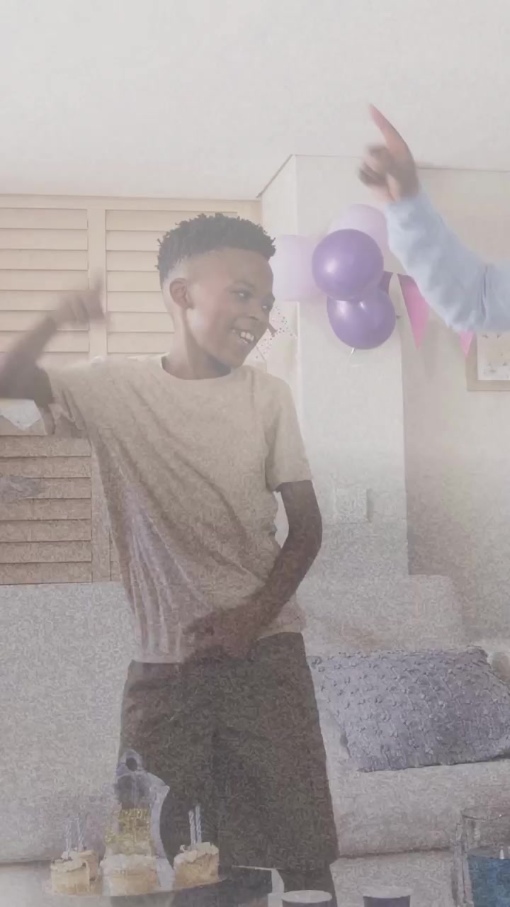 Vertical video: Son raising arm, dancing at birthday, mom serving cupcakes while confetti floating