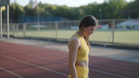 woman jogging on outdoor track in sportswear at athletic field