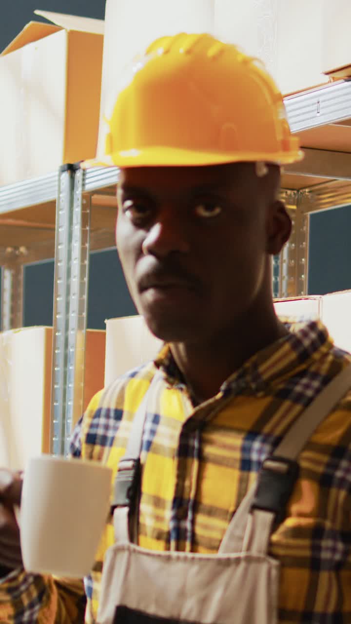 Vertical video: African american man posing next to boxes on racks