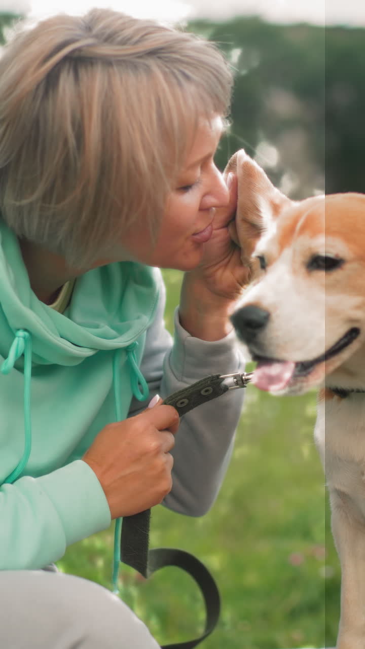 손에 목줄을 쥔 채 공원 벤치에서 비글에게 입을 맞추고, 장난기 넘치는 혀를 내밀고 귀를 부비는 모습. 다정한 인사, 부드러운 쓰다듬기, 웃음, 목줄 조절 등이 프레임에 담겨 있으며, 햇볕이 잘 드는 풀밭 배경이 함께합니다.