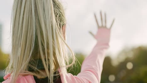 handheld video shows of jogging woman with hand raised