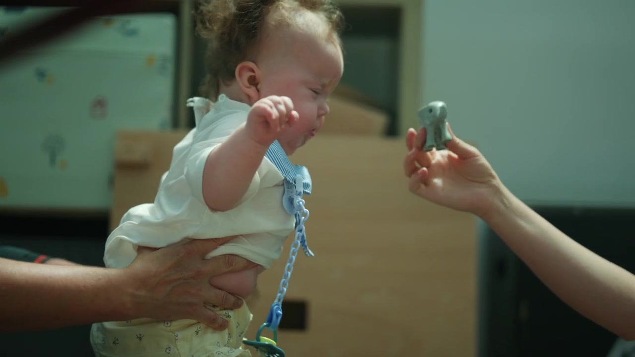 Therapist or parent holding an infant in a prone position, focusing on pediatric physical therapy and early childhood development
