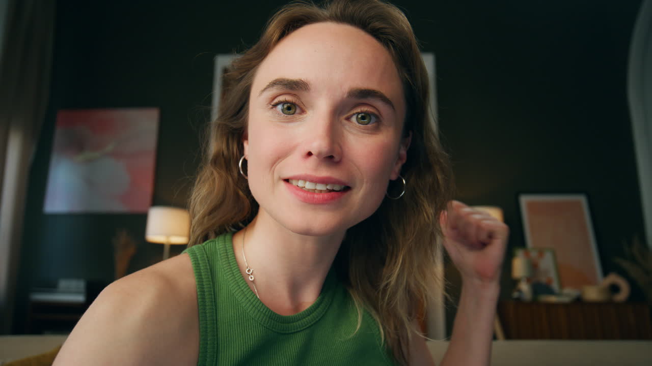 una chica alegre hablando de la casa. una mujer sonriente haciendo gestos con la mano apuntando de cerca.