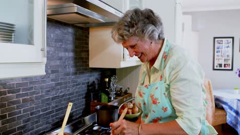 happy senior woman cooking food in kitchen 4k