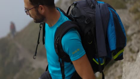 mochilero caminando por la ladera de la montaña en los alpes de lecco