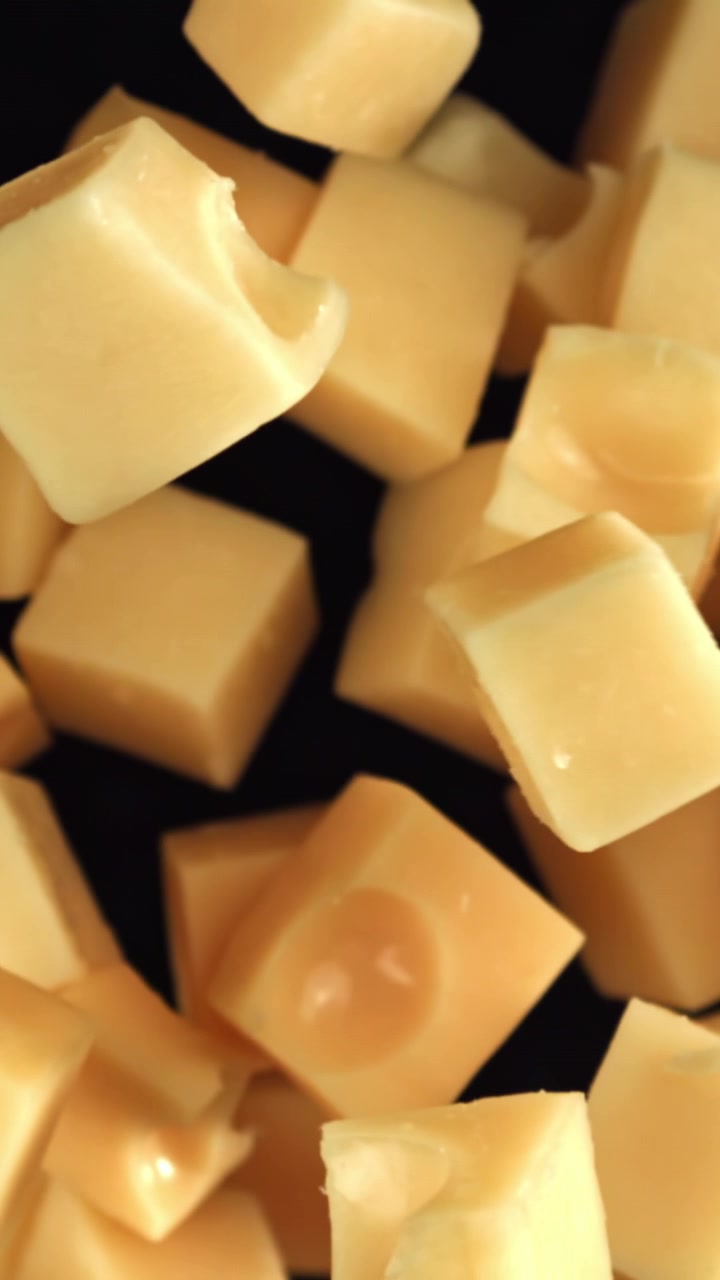 Délicieux cubes de fromage jaune tombant au ralenti